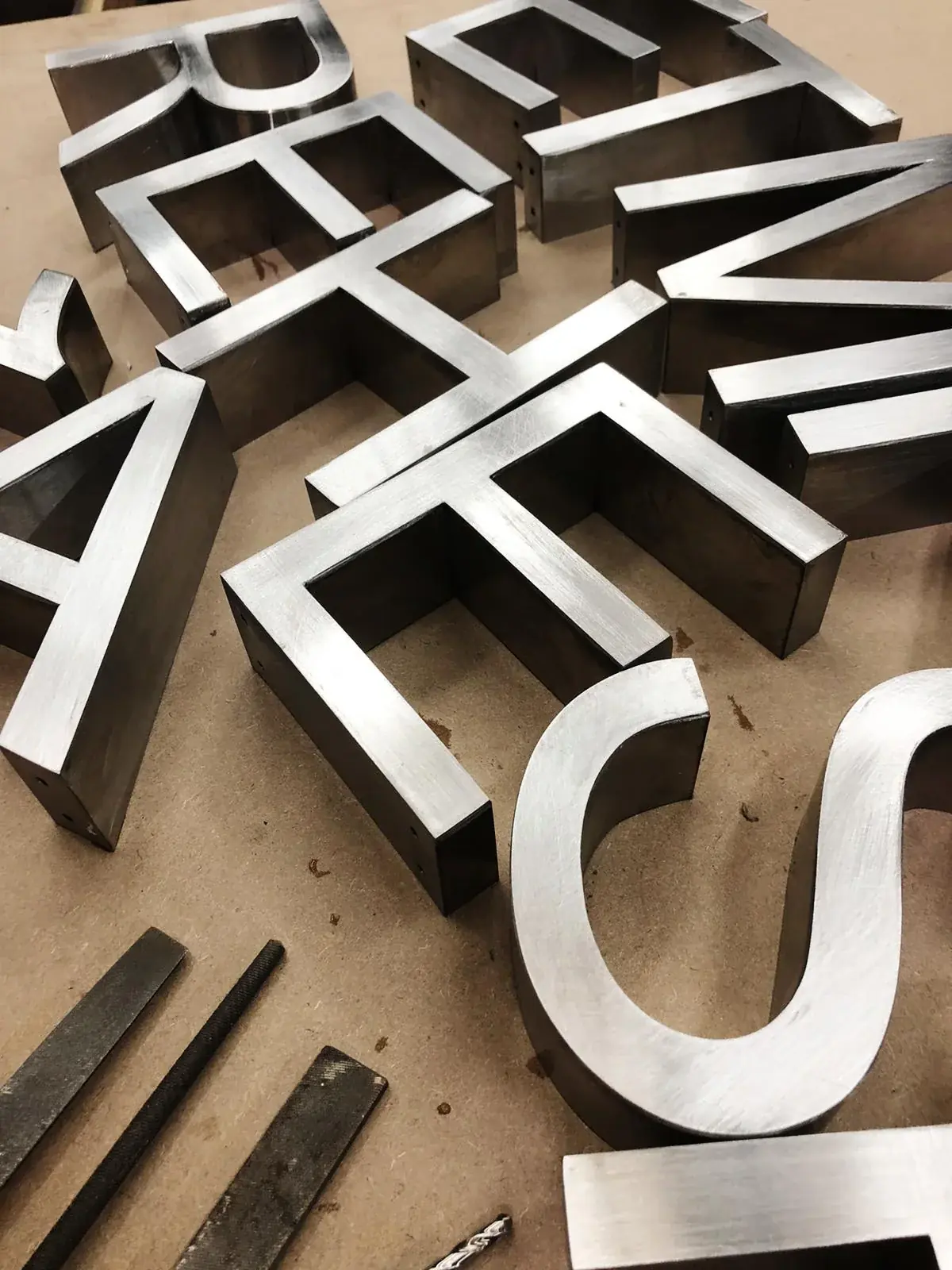 Quality brushed-metal 3D Built-Up Letters arranged in the workshop — 3D Built-Up Letters example for Spitalfields E1