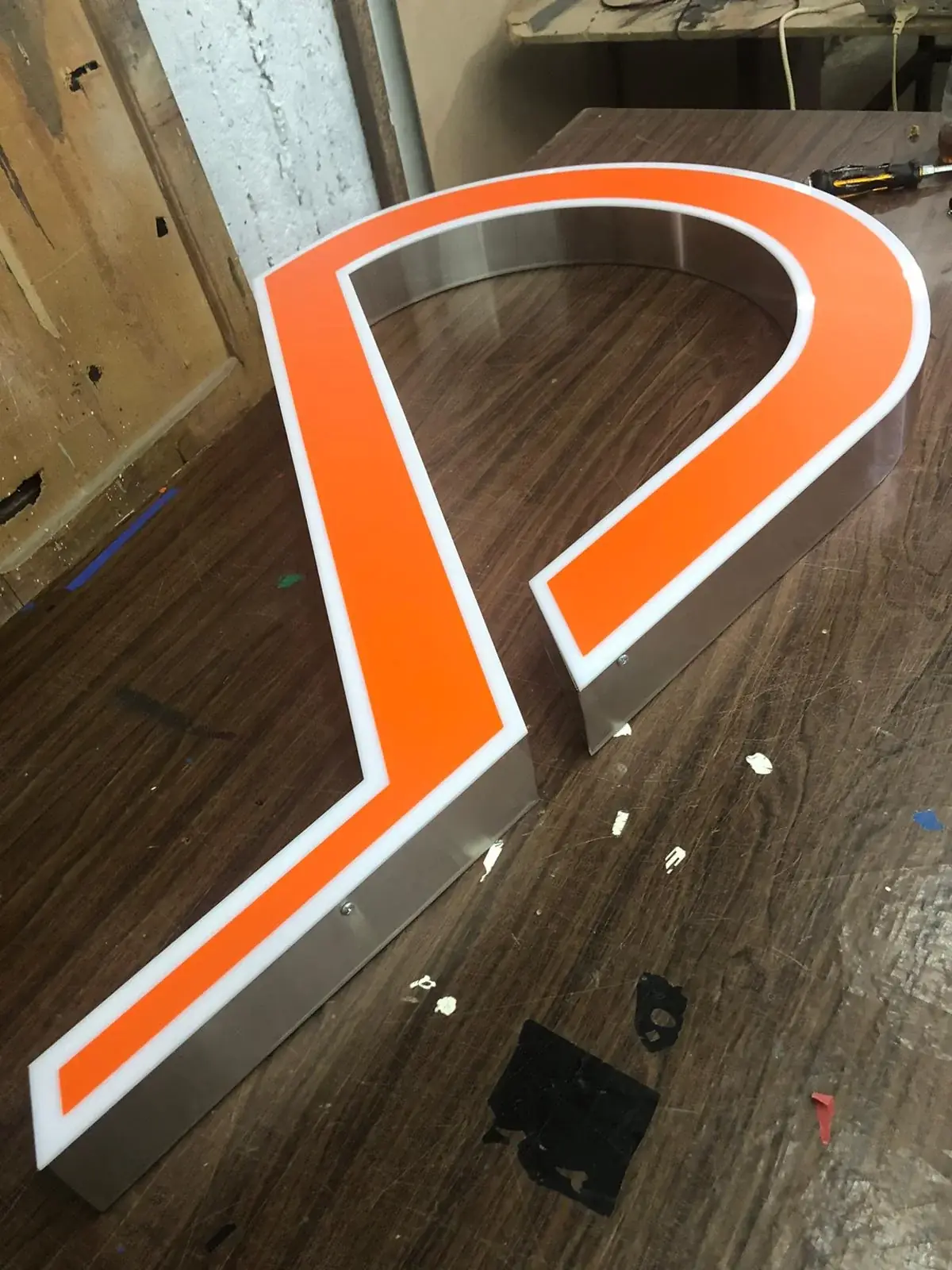 Orange-faced built-up letter with white acrylic border and stainless-steel return — 3D Built-Up Letters example for Forest Gate E7