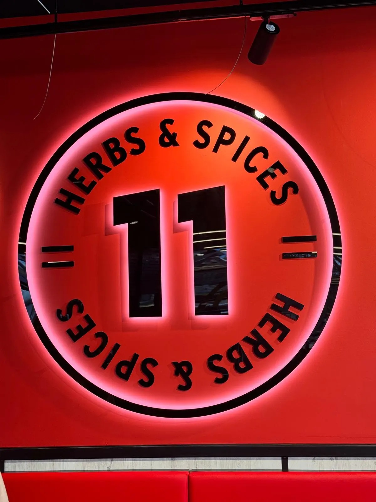 Illuminated circular Herbs and Spices sign with dimensional black lettering