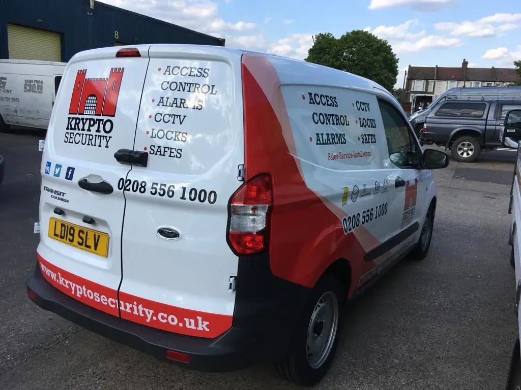 Rear-quarter view showing coordinated Krypto Security side and rear van graphics