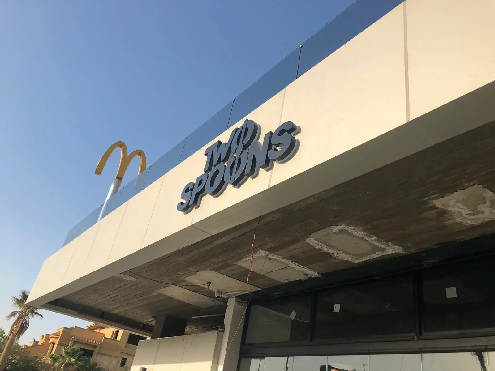 Completed Two Spoons exterior built-up letters viewed from below against the light fascia