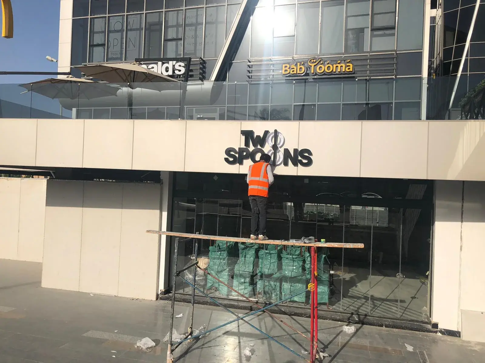 Two Spoons dimensional fascia lettering being installed above the glazed frontage