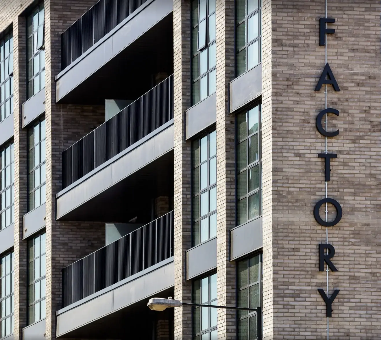 Close architectural view showing the depth and spacing of the Bagel Factory letters