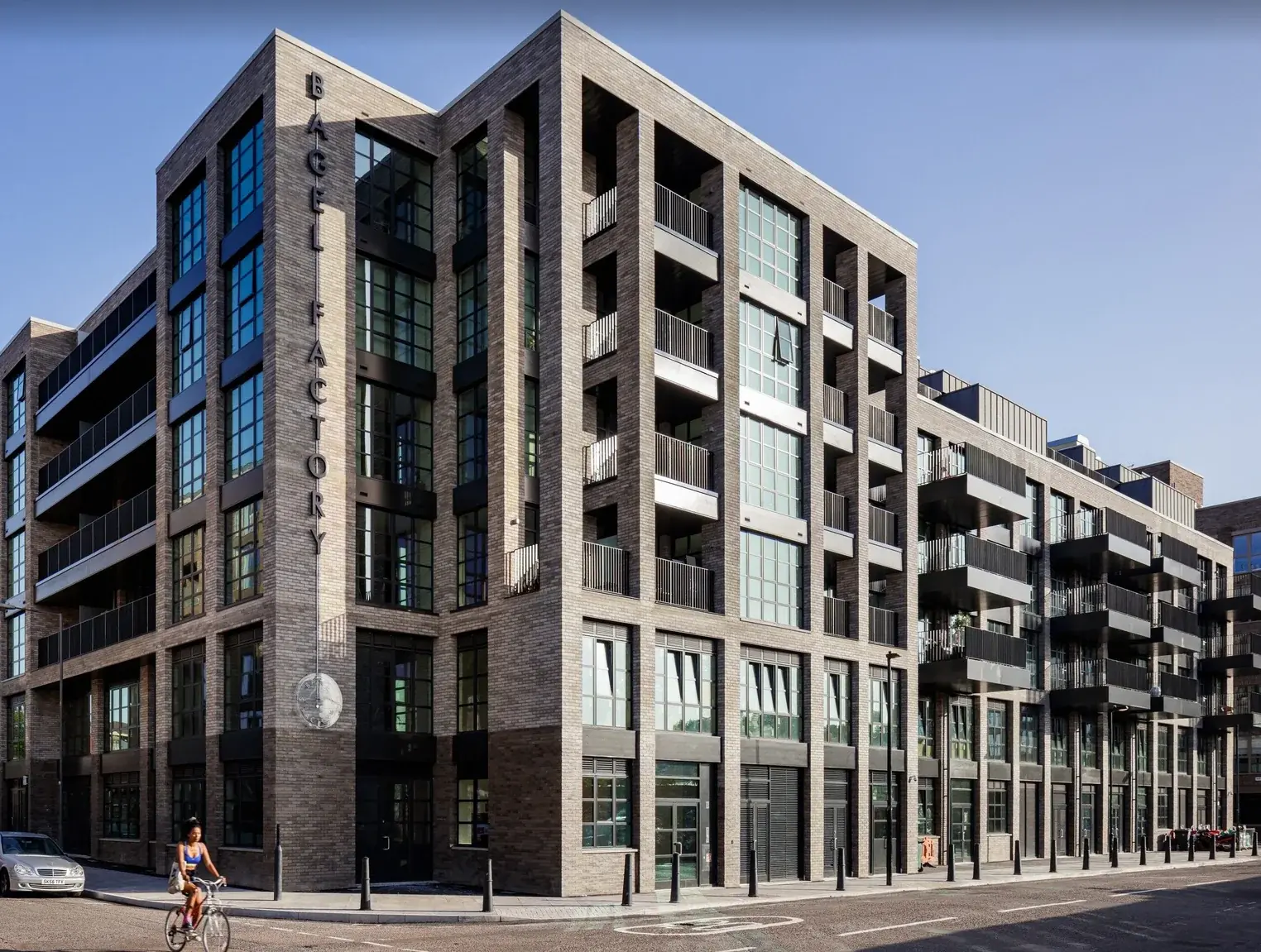 Completed Bagel Factory building with vertical exterior lettering visible from the road