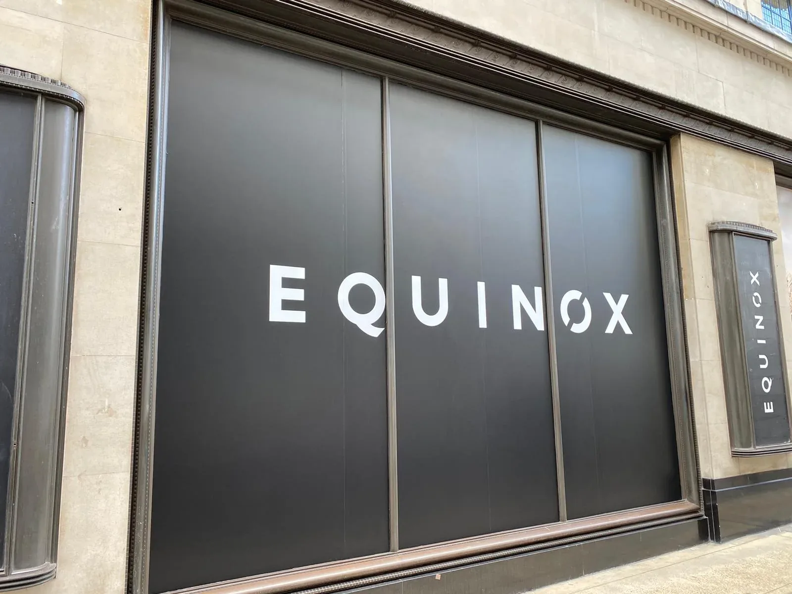 Black Equinox window graphics with large white logo lettering across the glazing