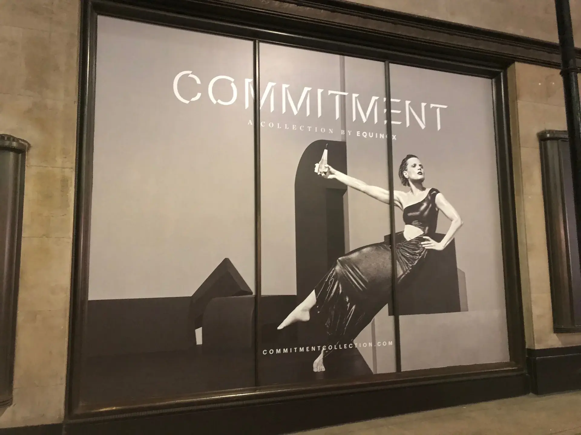 Angled street view of seated-model artwork covering the Equinox window