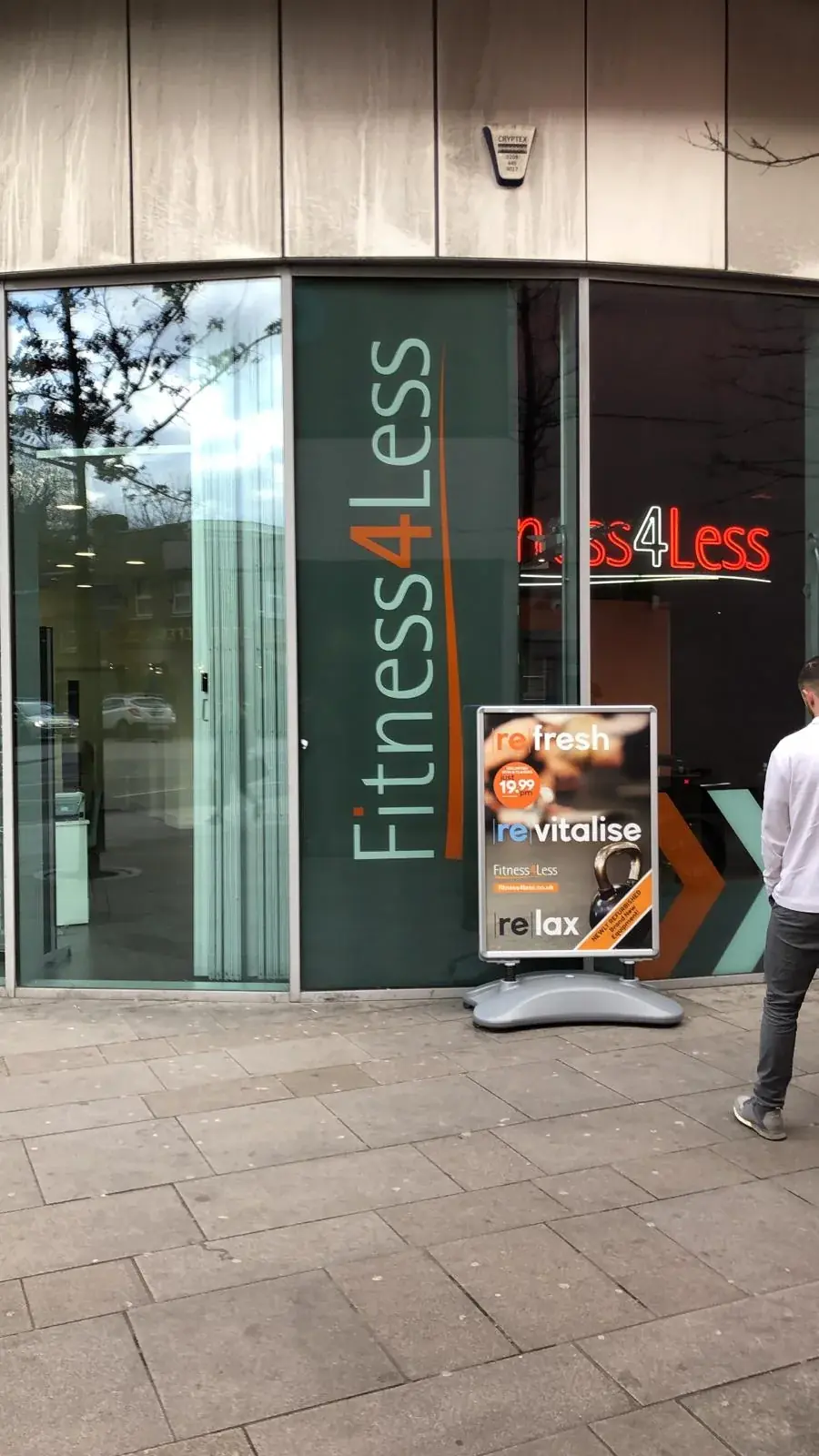 Fitness4Less shopfront branding viewed along the curved glass frontage