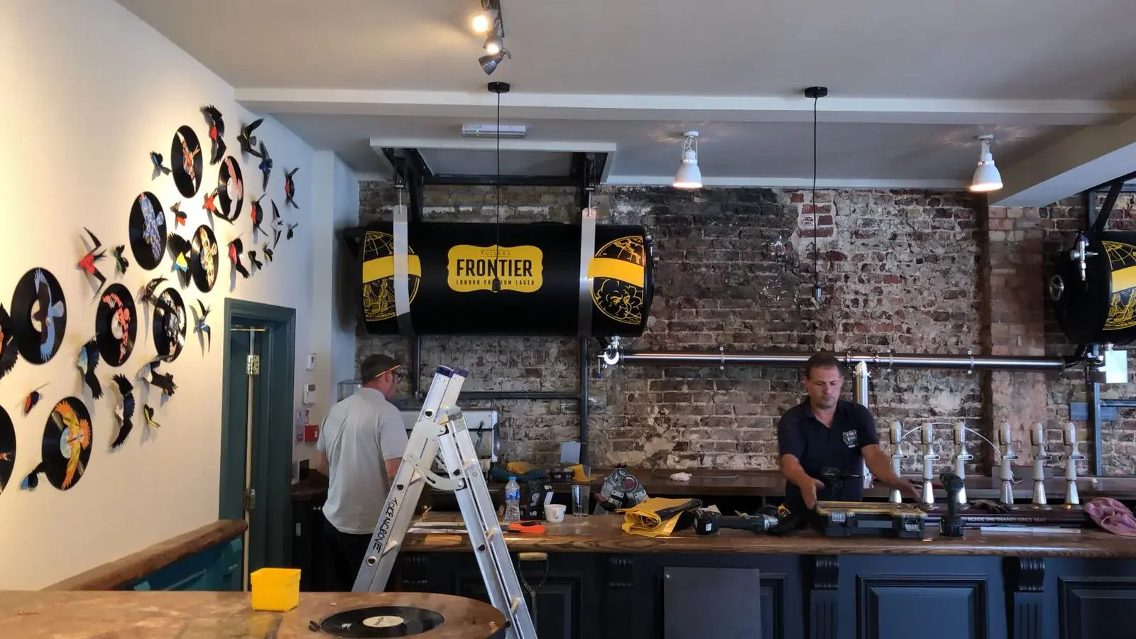 Frontier full beer tank wraps installed above the bar in a hospitality interior, gallery image 14