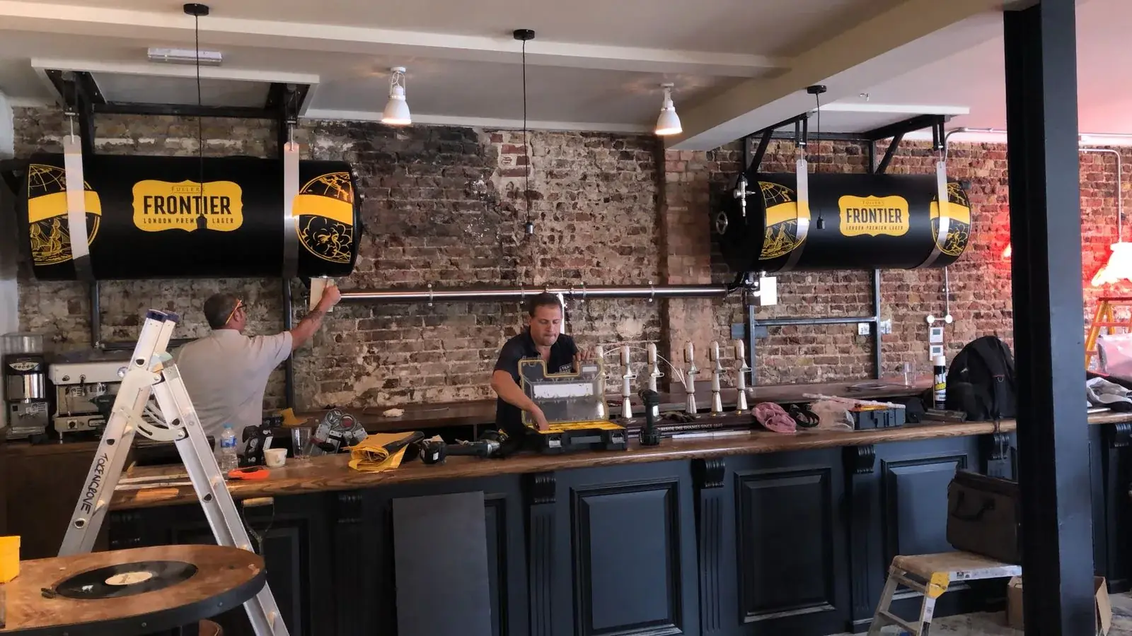 Two beer tanks being fully wrapped with black and yellow Frontier branding, gallery image 12
