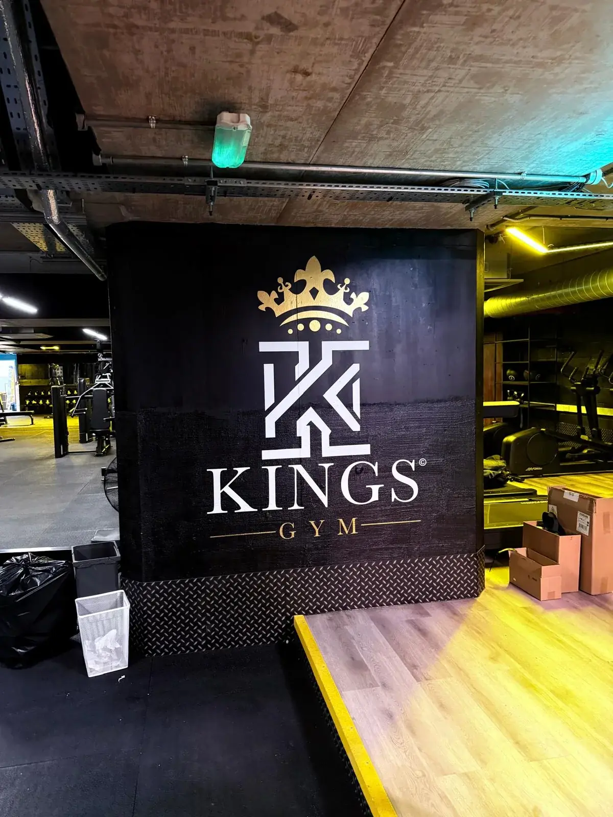 Large Kings Gym crown, K monogram and wordmark installed on a black feature wall