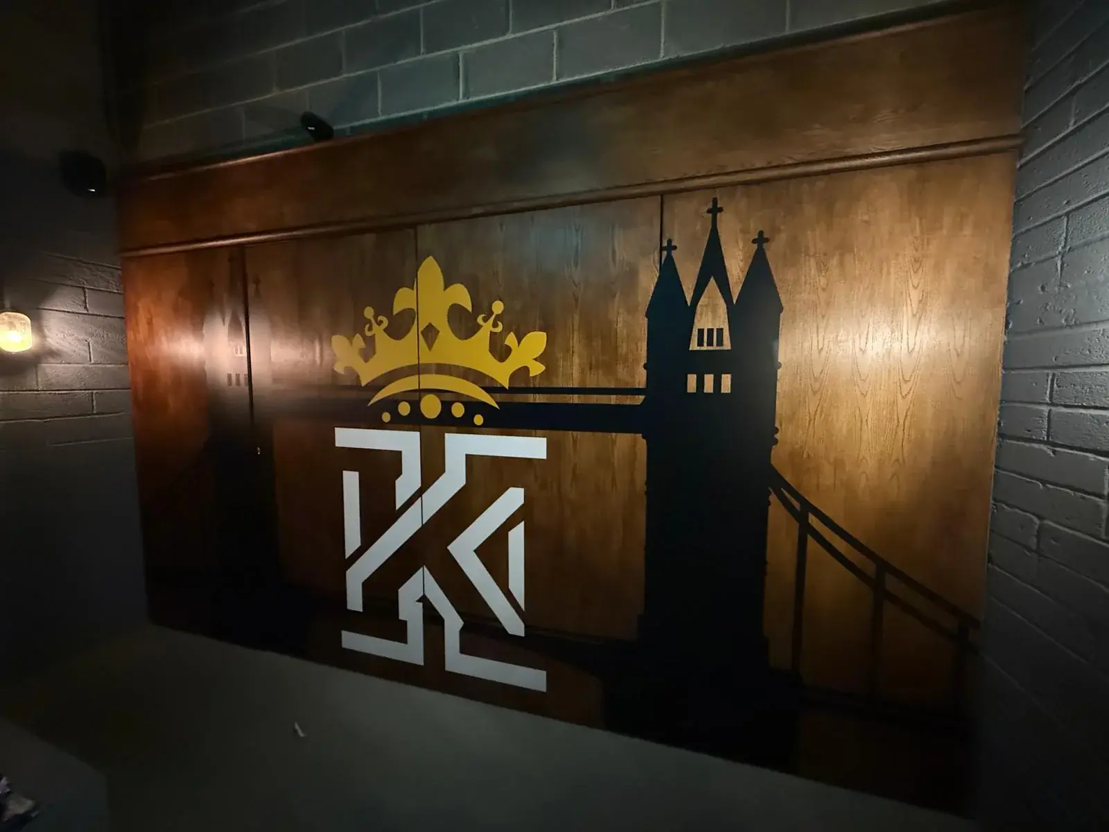 Kings Gym crown and K identity combined with a Tower Bridge silhouette on a timber wall
