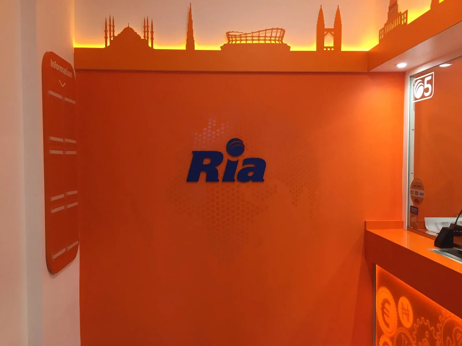 Dimensional blue Ria logo on an orange interior feature wall