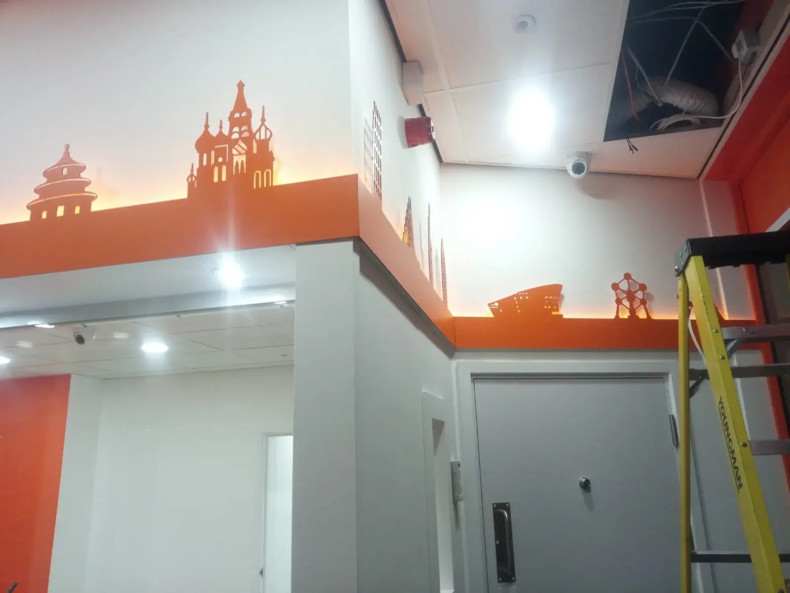 Illuminated international skyline graphics around the Ria branch interior