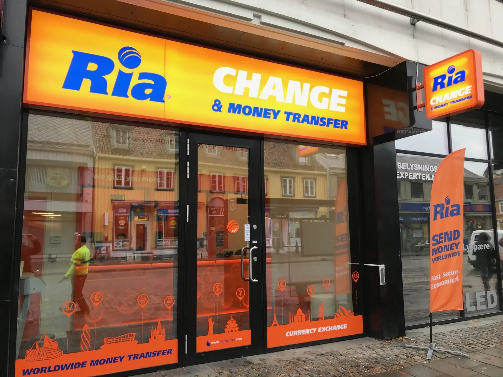 Ria storefront with orange window graphics for worldwide money transfer and currency exchange