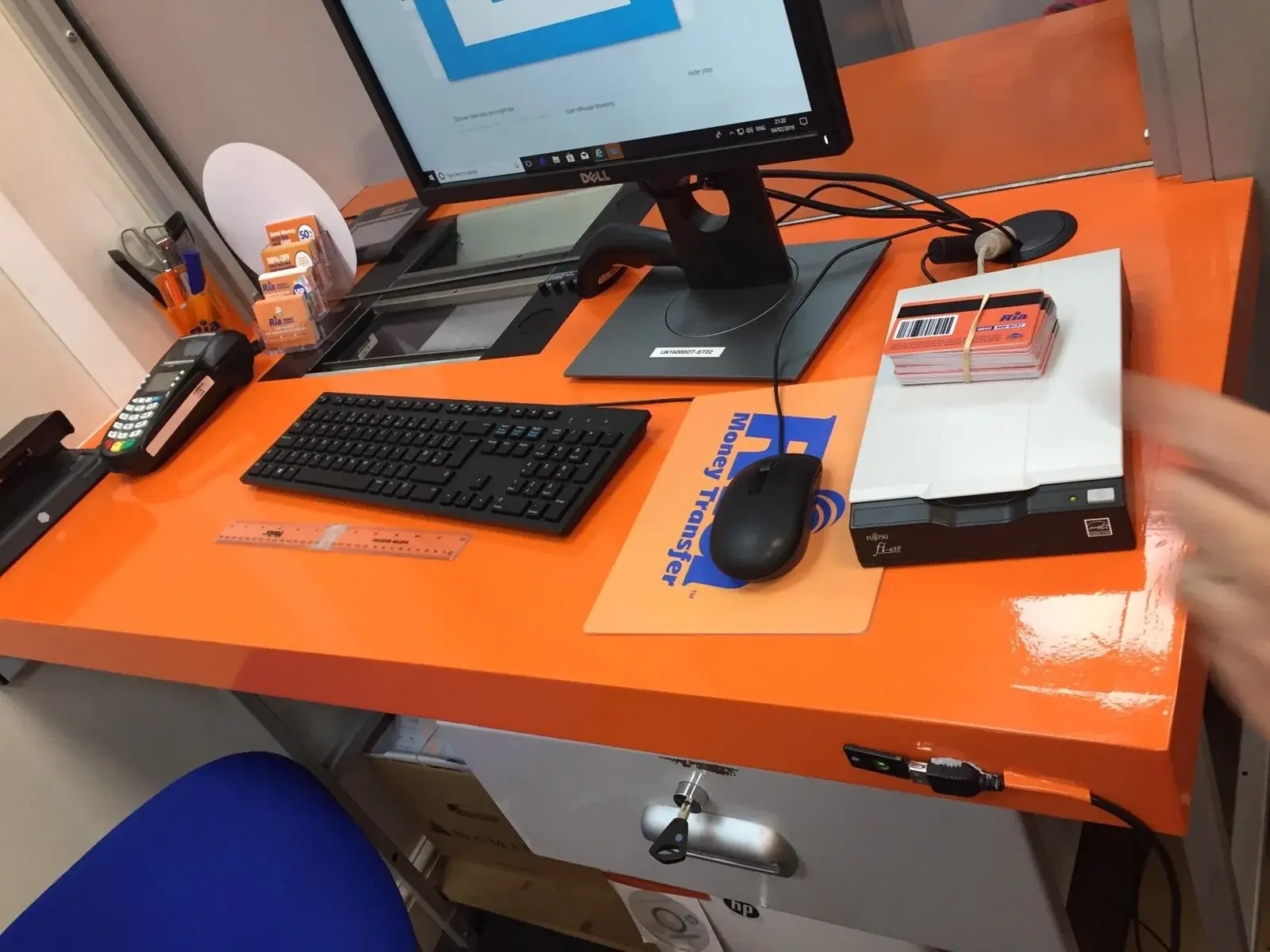 Orange Ria customer-service desk with equipment and branded interior finishes