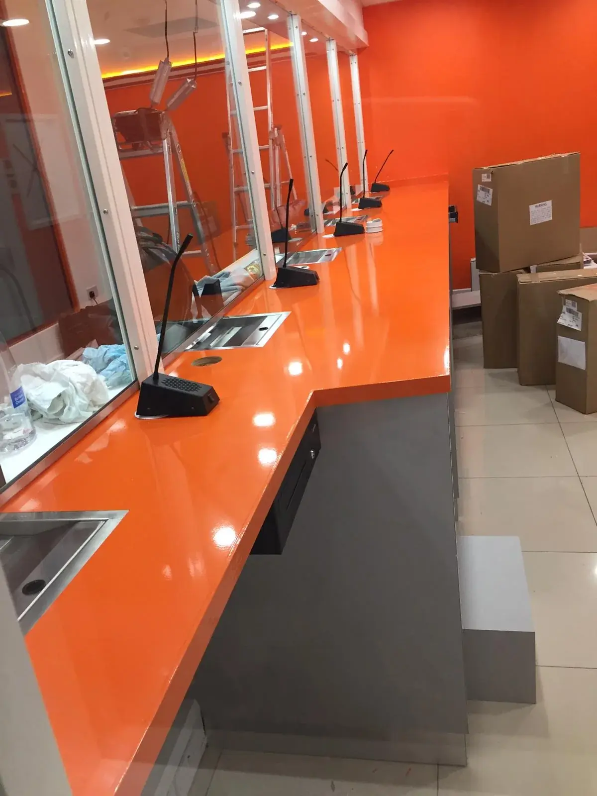 Gloss orange Ria service counter during the interior installation