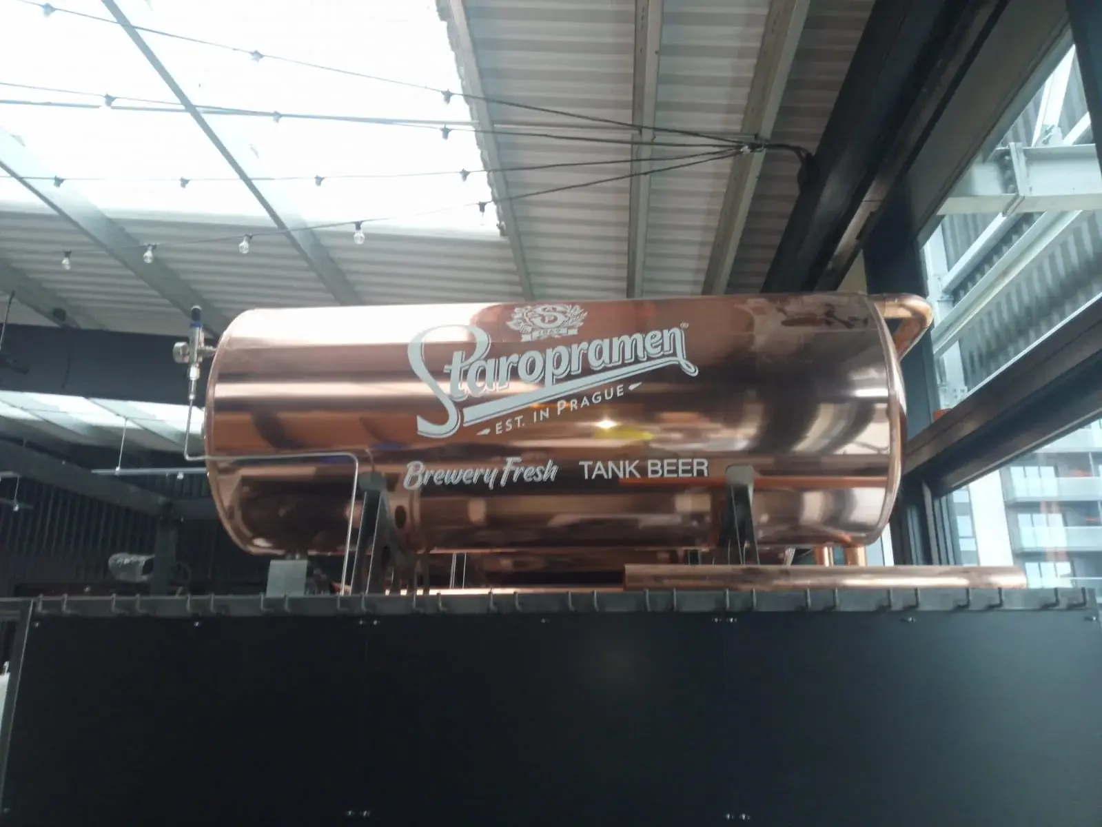 Front view of Staropramen tank vinyl branding in a hospitality interior, gallery image 6