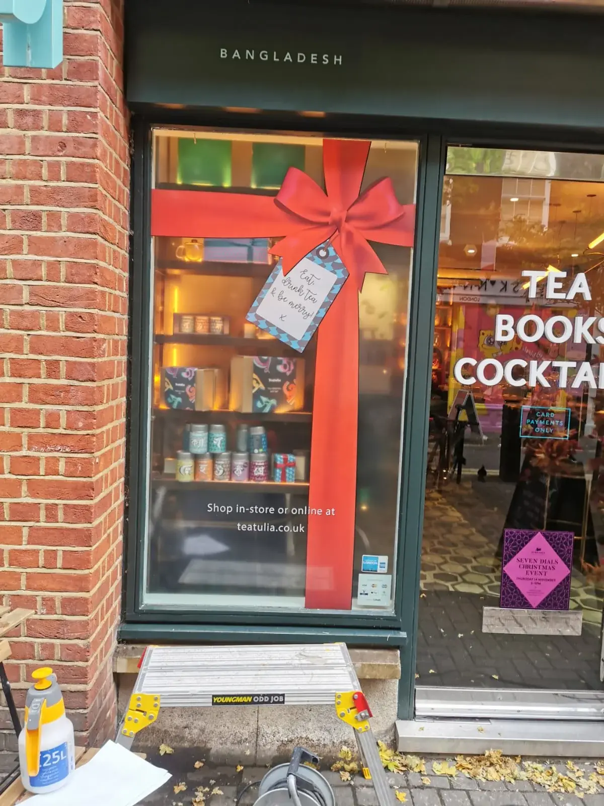 Full-height red ribbon and bow window vinyl installed on a retail frontage